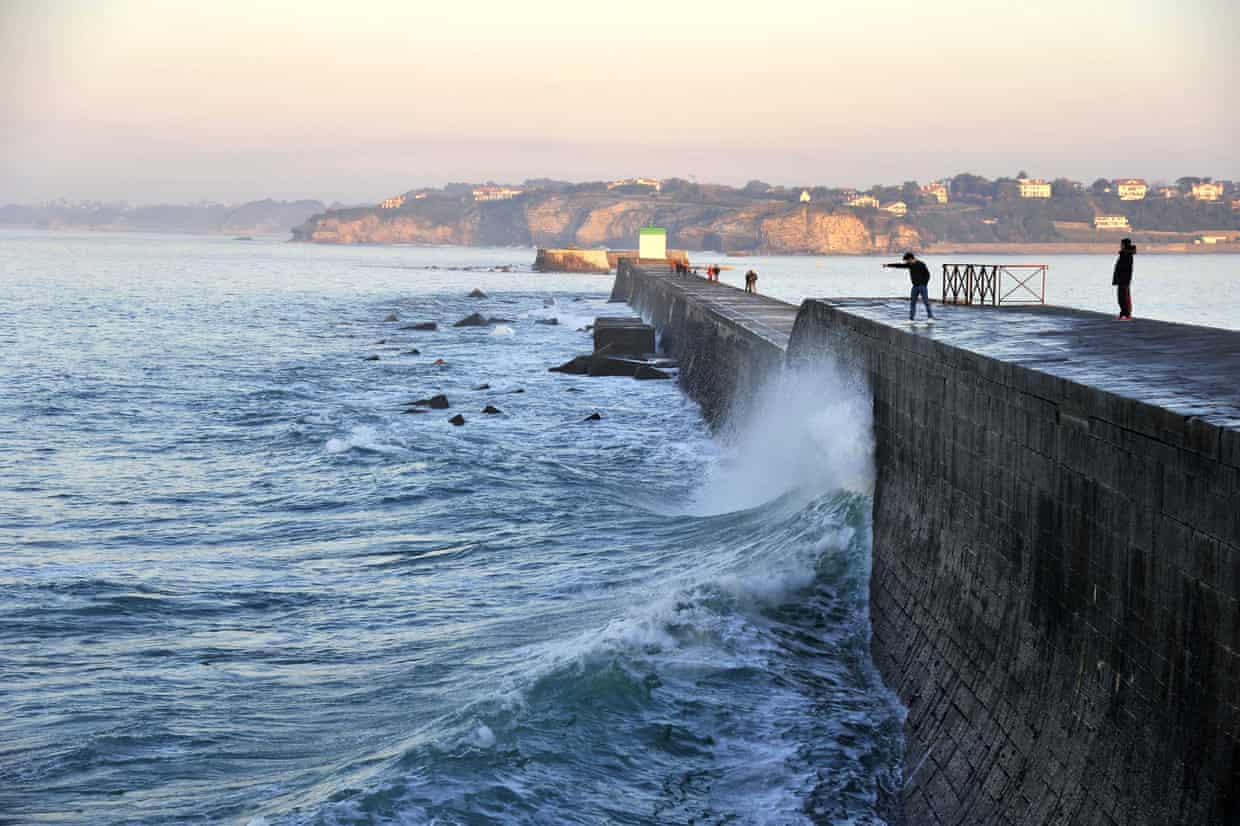 A harbour wall with waves crashing against it