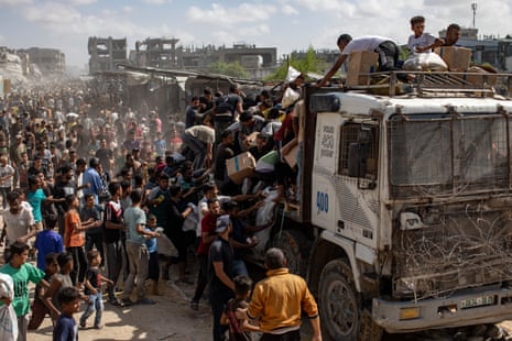 Palestinians take aid supplies from a truck