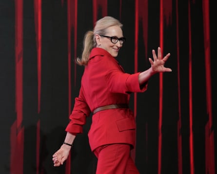 Meryl Streep wearing red waves as she steps behind a curtain