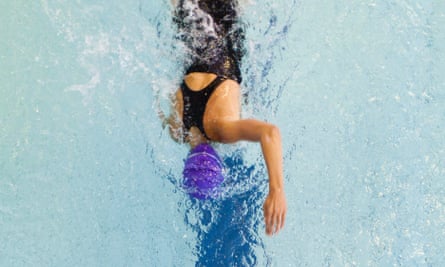 A birds-eye view photograph of a female swimmer in a swimming pool. 