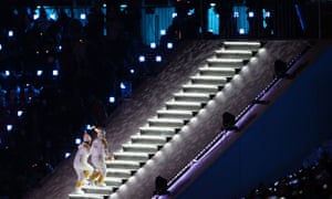 Ice hockey players from North and South Korea climb the stairs with the Olympic torch.