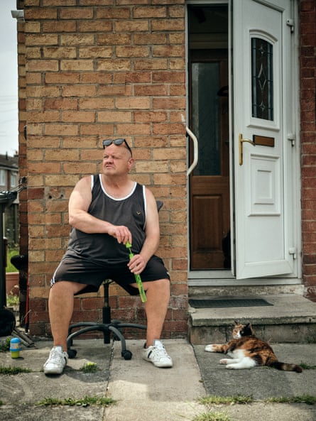 David Taylor entertains his cat Mia outside their home in Miles Platting, Manchester