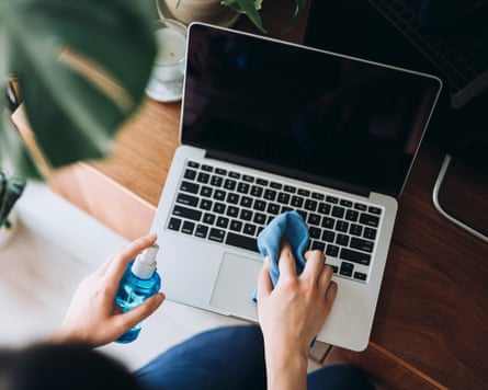 Cropped shot of a young woman cleaning the surface of laptop with cleaning spray and antistatic cloth at home