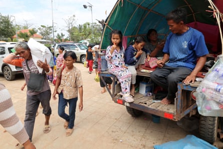 Cambodian evacuees carry relief items at a safe zone in Siem Reap.