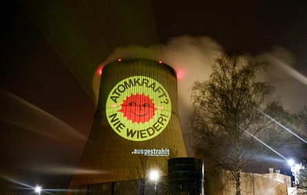 a nuclear power no thanks slogan beamed on to the chimney of a nuclear reactor
