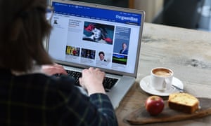 A woman reads the Guardian website