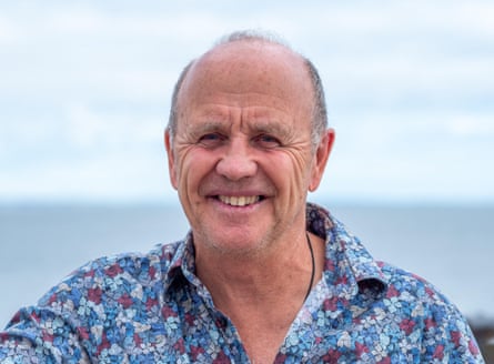 A head-and-shoulders photo of Doug Allan smiling in a flowery shirt
