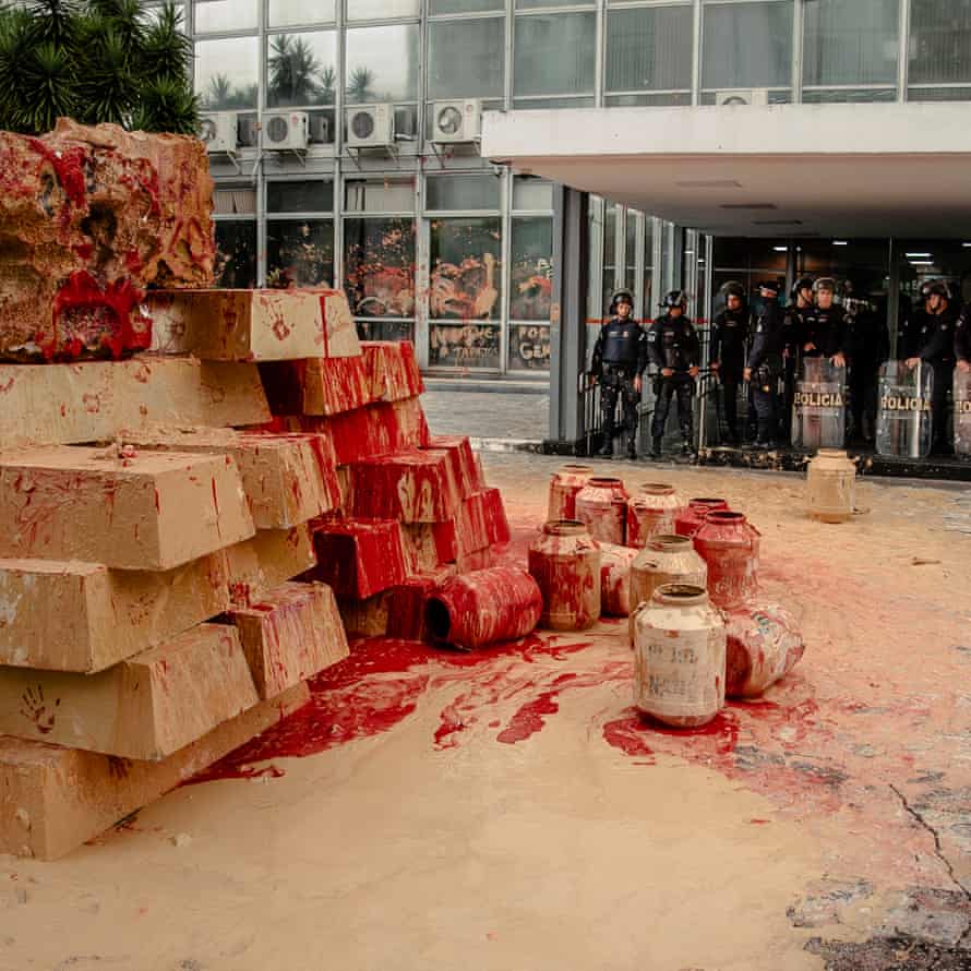 Uma instalação feita de barro, representando lama tóxica da mineração, e tinta vermelha, representando sangue indígena derramado, fica do lado de fora do Ministério de Minas e Energia, em Brasília