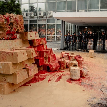 An installation made of clay, representing toxic mud from mining, and red ink, representing spilled Indigenous blood, stands outside the Ministry of Mines and Energy in Brasília