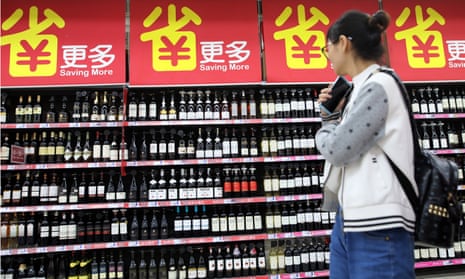 A consumer walks by wine products on the goods shelf at a supermarket in Beijing. China has announced tariff hikes on a list of US goods.