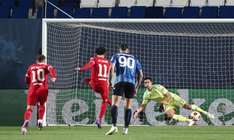 Mohamed Salah of Liverpool scores his team's first goal from a penalty kick past Juan Musso of Atalanta.
