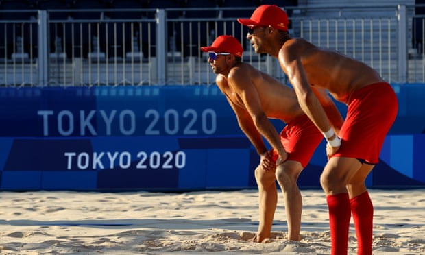Spanish beach volleyball players practice in Shiokaze park in Tokyo. Staff have had to hose down the hot sand.