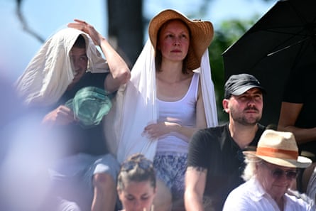 Spectators hide from the sun as they watch Iva Jovic play Emma Navarro.