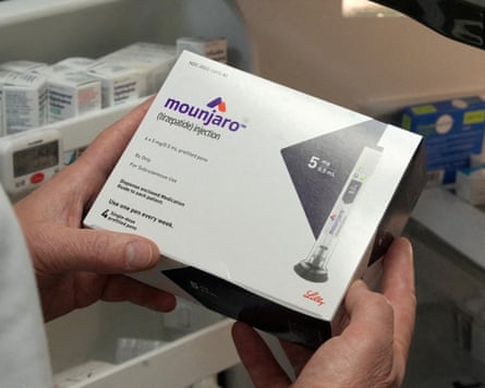 A pharmacist displays a box of Mounjaro