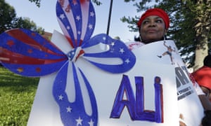 Frances Woods holds a sign saluting Muhammad Ali as she awaits his funeral procession to make its way down Muhammad Ali Boulevard in Louisville, Kentucky.