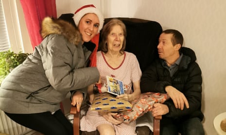 Kathleen Poole holding Christmas presents with her son Wayne and daughter-in-law Angelica