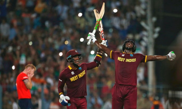 West Indies Carlos Brathwaite and Marlon Samuels celebrate after winning the final. England’s devastated Ben Stokes is in the background.