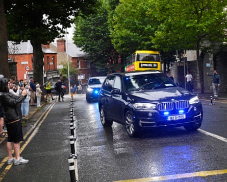 Onlookers take photos as the car carrying Daniel Kinahan passes