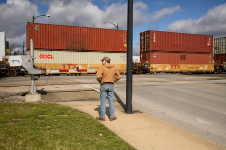 A man stands by as a Norfolk Southern train passes in East Palestine, Ohio.