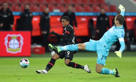 Leon Bailey scores his second goal for Leverkusen against Hoffenheim despite the efforts of Oliver Baumann.