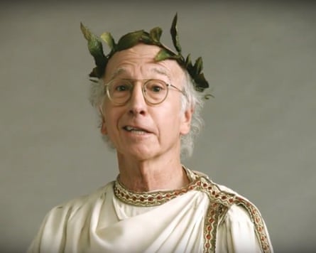 Larry David, wearing glasses, a leaf crown and toga, speaks to camera in Curb Your Enthusiasm
