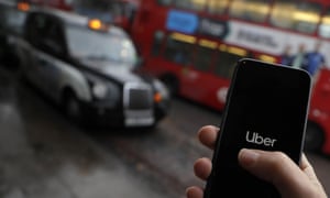 O aplicativo Uber em um telefone celular, com um táxi preto e busto vermelho de Londres ao fundo