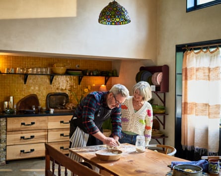 A man and a woman making bread in a kitchen