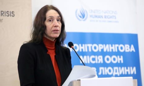Matilda Bogner in front of a podium with a microphone, in the background there is a UN human rights sign with Russian writing
