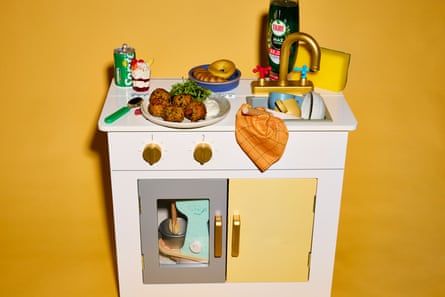 Child's play kitchen with washing-up liquid, and food on a plate