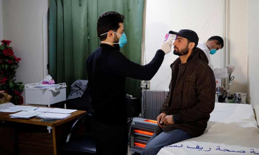 A passenger in Jdaydet Yabous, Syria, is tested for coronavirus at a border crossing with Lebanon.