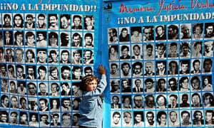 A boy holds a banner with pictures of some of the 3,000 people killed or disappeared during Augusto Pinochet’s dictatorship (1973-90). Pinochet faced charges over the deaths of political opponents under Operation Condor.