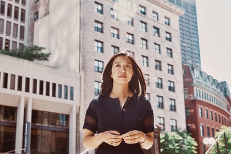A woman stands for a portrait in front of buildings