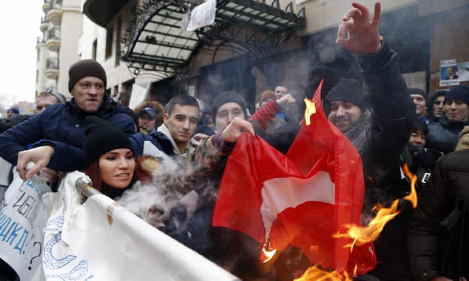 Russians burn a Turkish flag during a rally outside the Turkish embassy in Moscow after the jet was shot down.