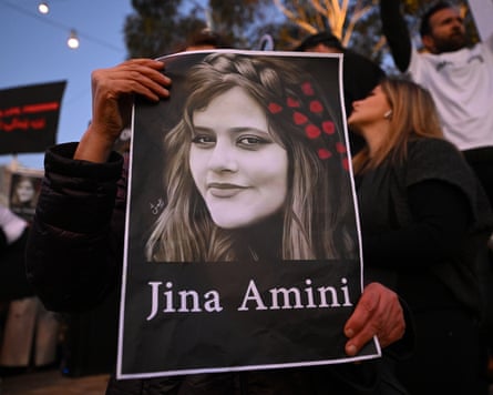 A protester holds a poster with the image of Mahsa Amini