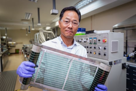 Man in a lab coat holding a transparent film