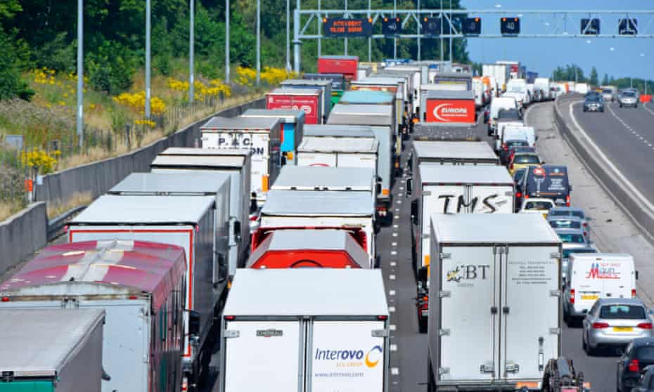 An accident on the M25 motorway, England, gridlocks lorries adding to pollution from vehicle fumes.