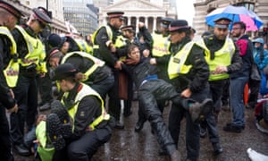 Environmental activists are arrested in central London on Monday.