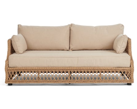 A two-seater wicker-framed sofa. The sofa has one sand coloured cushion at the base, two back rest cushions and a small cushions at either side.