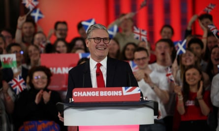 A smiling Keir Starmer standing at a lectern with branding on it reading ‘Change begins’