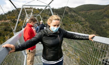 A visitor grips both sides of the bridge as she attempts to walk its 516 metre-span.