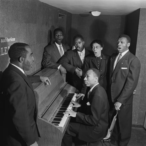 black and white picture of a group of musicians around a piano