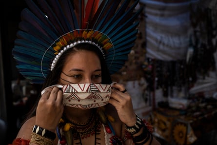 Samela Sateré-Mawé, 23, shows a protective mask made by her women’s association in Manaus, Brazil