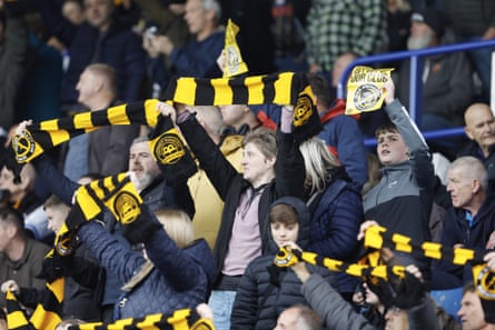 Sheffield Wednesday fans hold up scarves as they protest against the club’s owner Dejphon Chansiri.