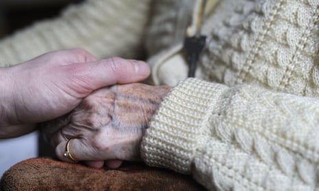 A young person clutching the hand of an elderly person