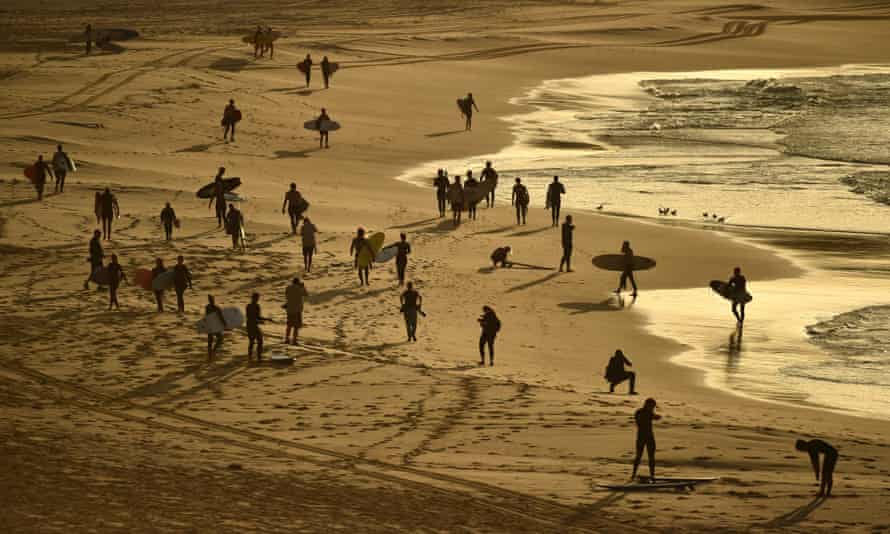Surfers and swimmers head to the ocean after Bondi Beach reopened following a five week closure in Sydney on Tuesday.