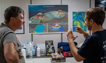 Nelson Kona et Tim O'Hara du CSIRO parlent devant un écran montrant une carte du fond de l'océan