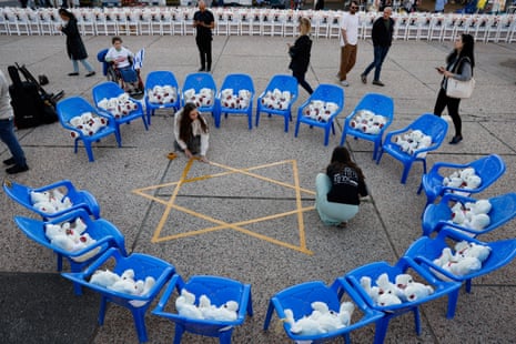 Israelis in Tel Aviv prepare an art installation of teddy bears with pictures of hostages being held by Hamas inside Gaza.