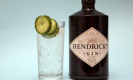 A bottle of Hendrick's gin and next to it a glass of gin and tonic.