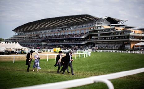 Guests walk across the racecourse during day five of Royal Ascot.