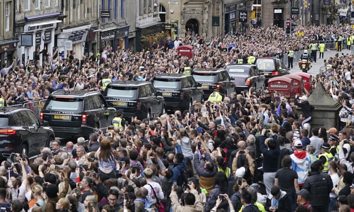 Crowds watch as the hearse carrying the coffin of Queen Elizabeth II passes Mercat Cross in Edinburgh on its journey to the Palace of Holyroodhouse.